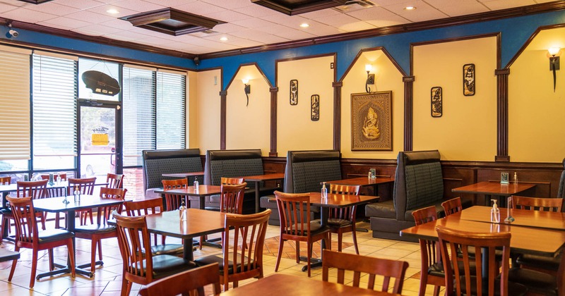 Interior seating area with booths, chairs and tables, traditional Thai decoration