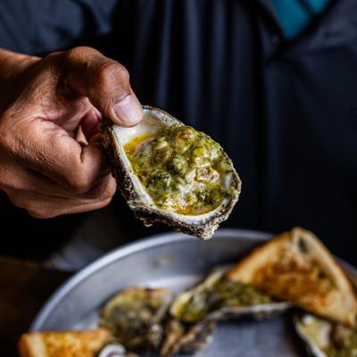 A hand holding an oyster.