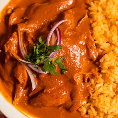 Chicken in Mole sauce, served with rice, beans, and guacamole.