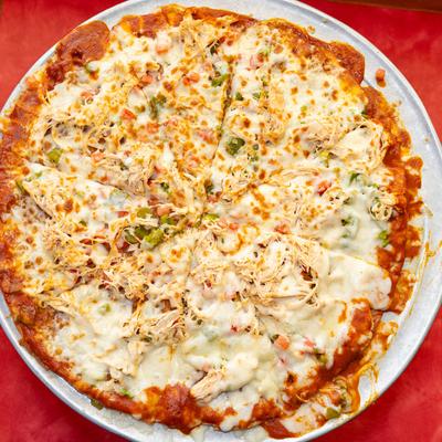 Pizza with melted cheese, green chiles, tomato, onion, enchilada sauce, and shredded chicken.