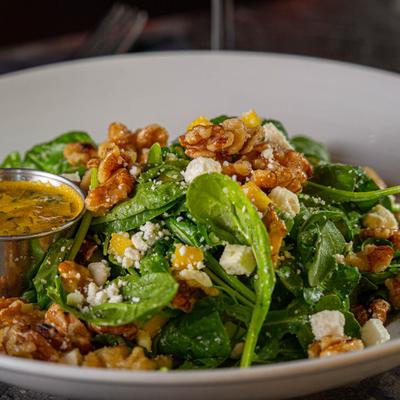 Green salad with walnuts and white cheese, and a dressing dip