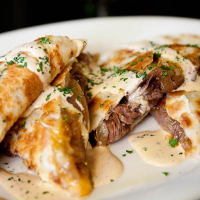 Steak quesadilla drizzled with a creamy sauce.