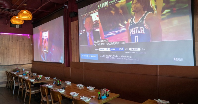 Interior, tables and chairs ready for guests, projector screen canvases on the wall