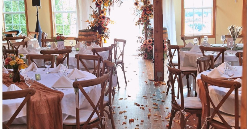 Interior, dining tables and seats by windows, bar area in the back