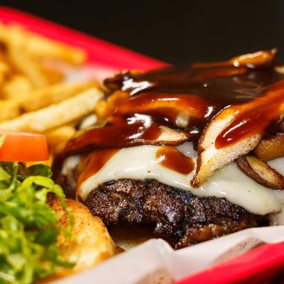 Mushroom Swiss Burger, with lettuce, tomato, mayo, sauce, and fries.