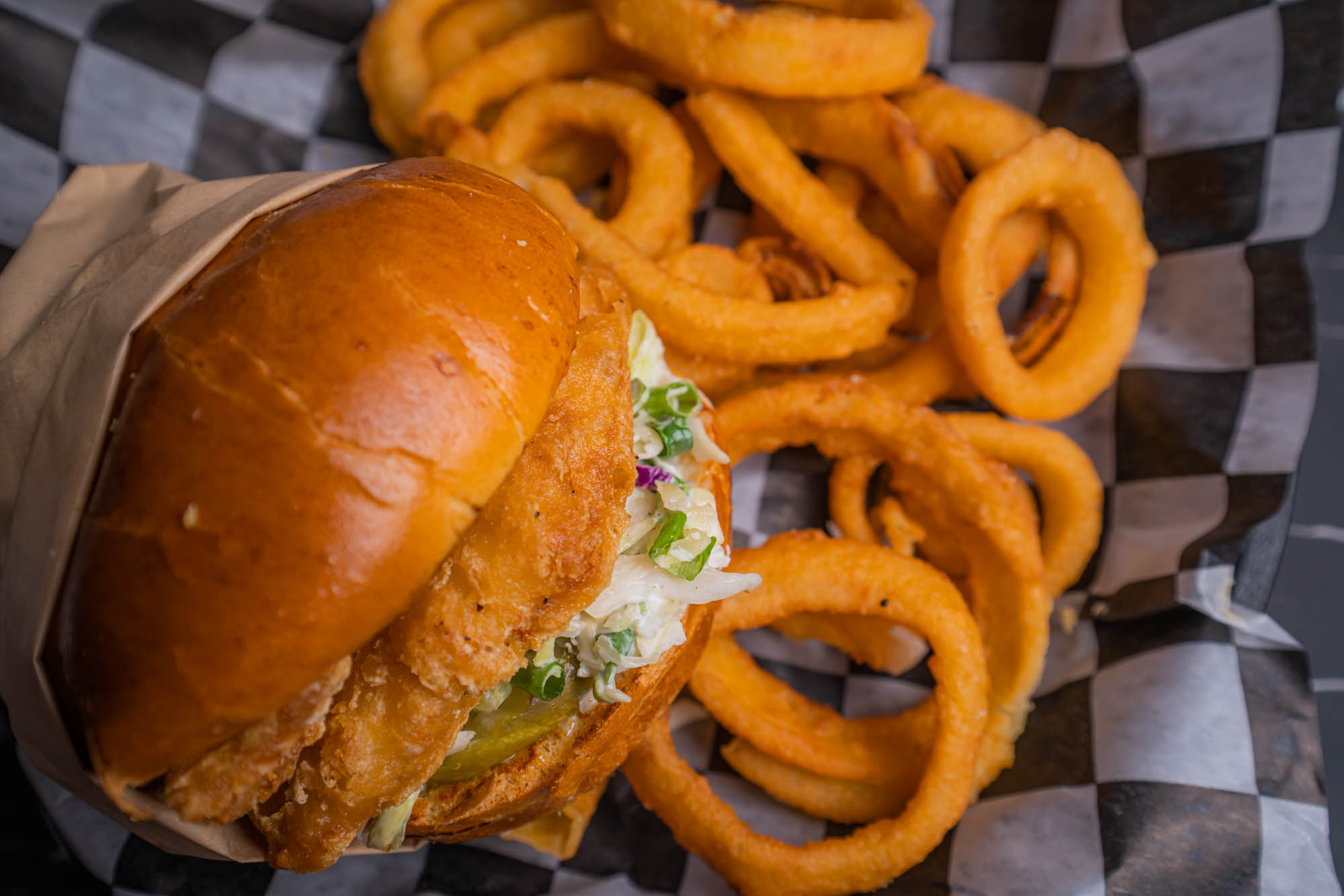 Closeup of a fish sandwich with onion rings