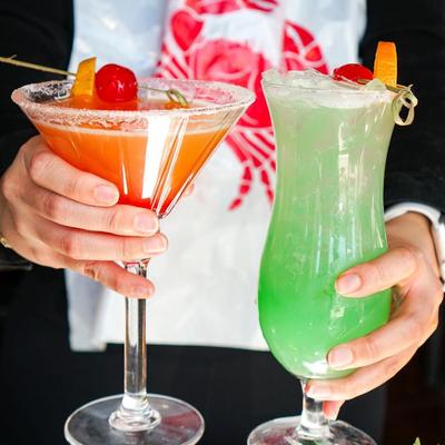 Person holding two different cocktails.