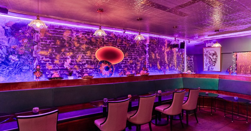 Decorated wall with lights, table, armchairs, angle booths