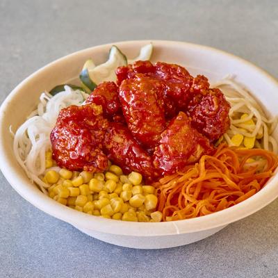 A bowl with sweet and sour chicken and vegetable ingredients.