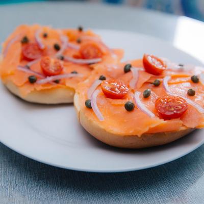 Bagels with cream cheese, salmon, red onion, and tomato