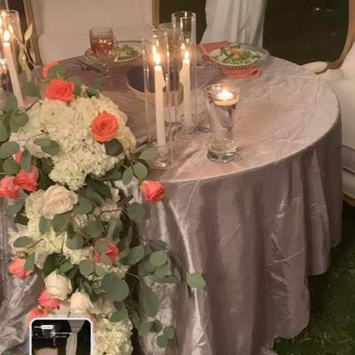 Floral centerpiece beside a candlelit table.