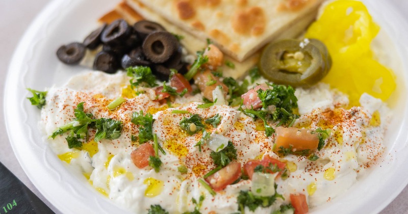 Tzatziki served with diced tomato, black olives, pickled vegetables and pita