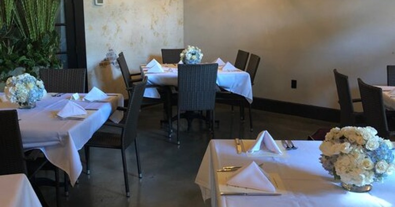 Fully set dining tables with floral centerpieces