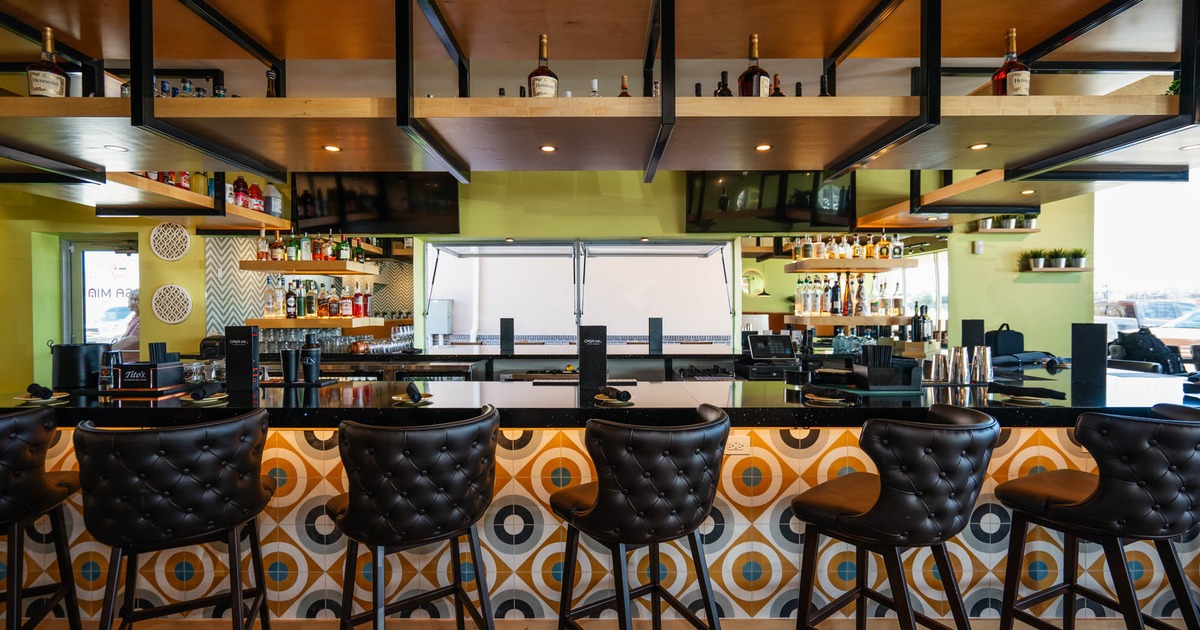 Interior, bar area, marble top bar with colorful tile front, leather padded bar stools