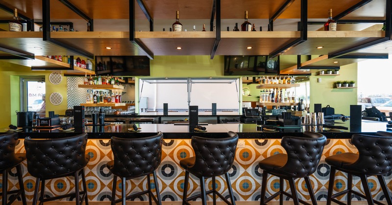 Interior, bar area, marble top bar with colorful tile front, leather padded bar stools