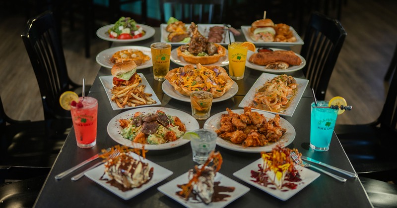 A wide display of pub dishes, appetizers, and bright drinks arranged on a table