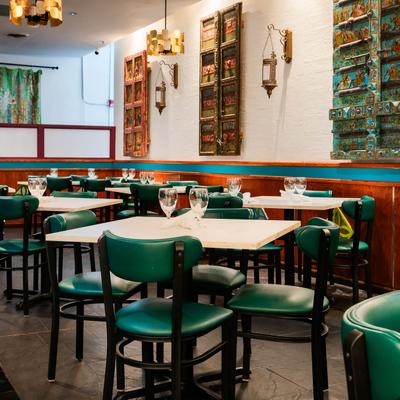 Interior, tables with glasses on them, wall decorated with rustic antique doors.