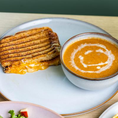 Bowl of Tomato Basil Soup paired with grilled cheese sandwich.