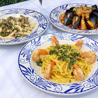 Three different plates of Italian-style pasta dishes served on the table.