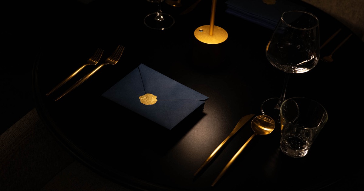 Elegant table setting with gold cutlery and blue napkin