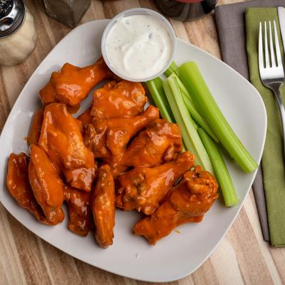 Hot chicken wings, with celery, and dressing.