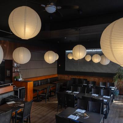 Interior with numereus paper lanterns, mix of booth and table seating.