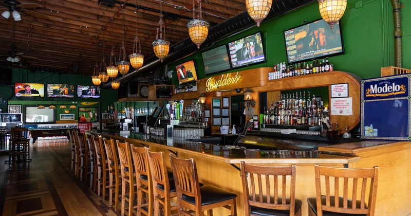 Bar area, lots of bottles, TV screens