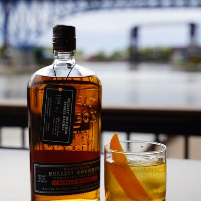 Old Fashioned cocktail served alongside a bottle of bourbon.