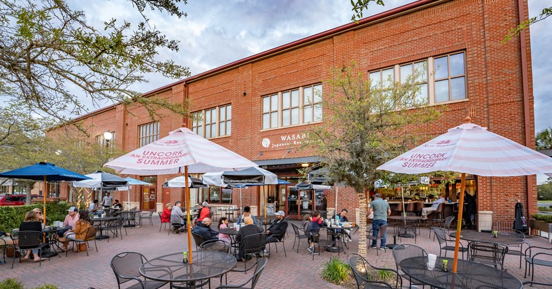 Exterior, patio with guests sitting around, tables with parasols