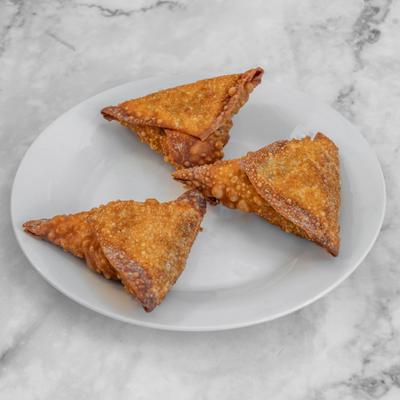 Fried samosas served on a white plate.