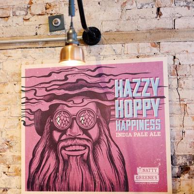 Hazy Hoppy Happiness IPA poster displayed on a brick wall.