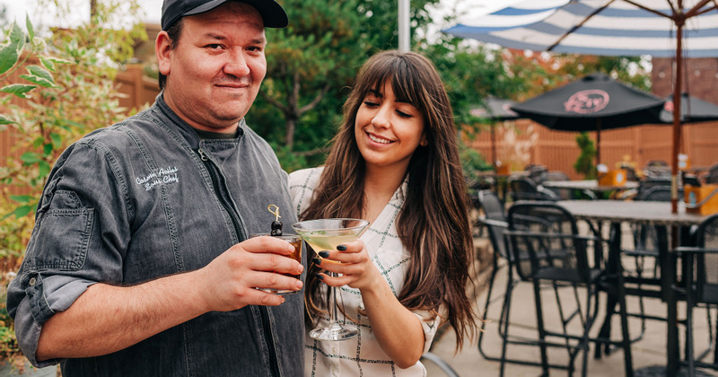 Two people toasting with cocktails