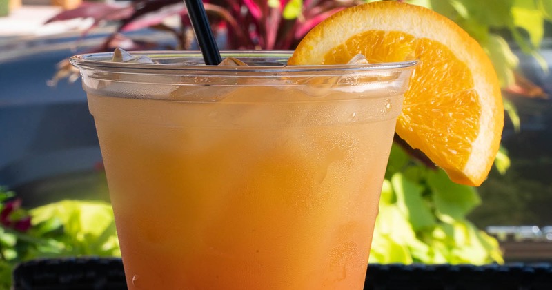 Vibrant orange drink garnished with an orange wedge