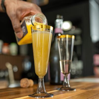 Bartender preparing mimosas at the bar.