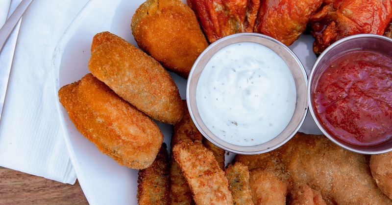 Fried chicken wings on plate with sauce in middle