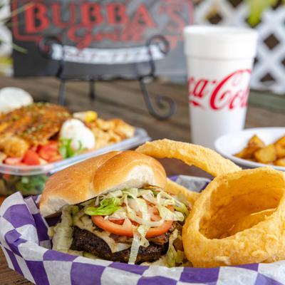 Mushroom Swiss Burger with a side of onion rings, alongside a drink and other dishes.