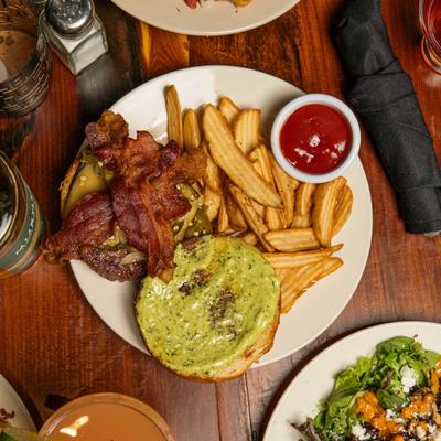 Burger topped with cheese, bacon and jalapenos, served with fries and a dip.