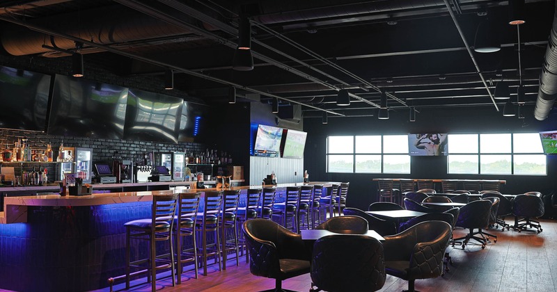 Interior -  a long counter, bar stools, flat-screen TVs and seating with black leather chairs
