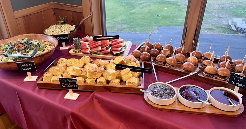 Buffet table featuring various food items with labels