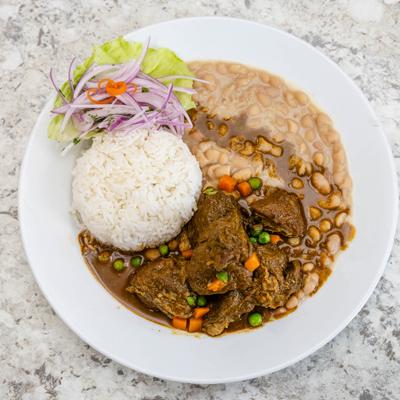 Peruvian beef stew served with rice and beans.
