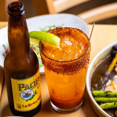 Michelada drink next to a bottle of beer.