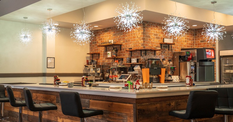 Interior of a cozy coffee bar with rustic decor and starburst lights hanging above a wooden counter