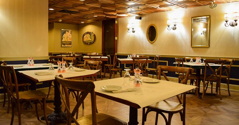 Interior, tables ready for guests, vintage wall lamps and mirrors on the walls