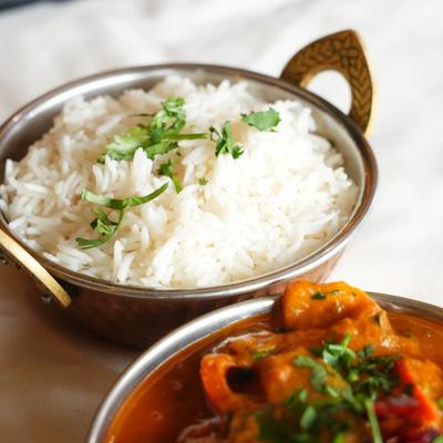 Chicken Karahi served with rice on the side, close-up.