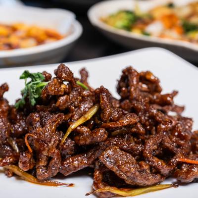 Crispy shredded beef served on the table alongside other dishes.