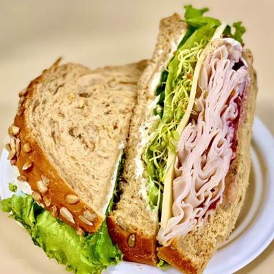 A turkey sandwich served on a white plate.