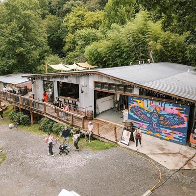Outdoor restaurant building surrounded by green trees.