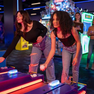 2 girls playing skeeball.