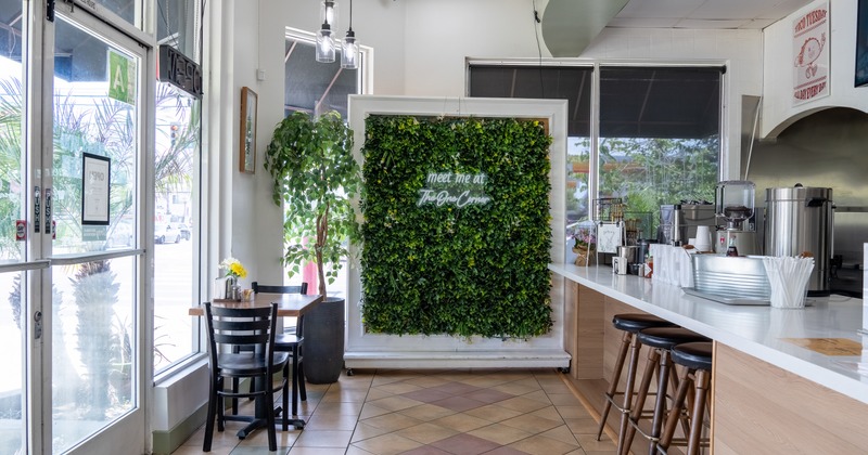 Interior, food counter, tables, xhairs, green plant wall