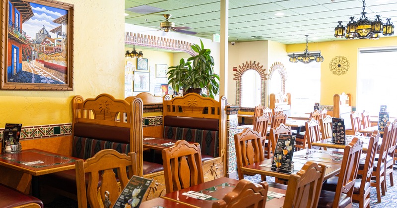 Interior of Mexican-style dining area with wooden tables and chairs